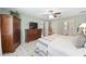 This bedroom offers tile floors, a ceiling fan, green walls, and dark wood furniture including a TV dresser at 923 Oleander St, The Villages, FL 32159