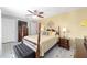 Spacious bedroom featuring tile floors, yellow accent wall, bed, ceiling fan, and dark wood furniture at 923 Oleander St, The Villages, FL 32159