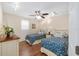 Charming bedroom featuring twin beds with matching floral bedding and hardwood floors at 923 Oleander St, The Villages, FL 32159