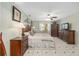 The main bedroom offers tile flooring, a ceiling fan, light green walls, a bed, and dark wood furniture at 923 Oleander St, The Villages, FL 32159