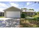 Charming single-story home with a well-maintained lawn, an attached garage, and a cozy screened-in porch at 923 Oleander St, The Villages, FL 32159