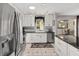 Well-lit kitchen featuring stainless steel appliances, white cabinets, granite countertops, and a view to the dining area at 923 Oleander St, The Villages, FL 32159