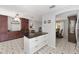 Kitchen with a granite-top island, white cabinets, tile floor, and extensive dark wood storage and shelving at 923 Oleander St, The Villages, FL 32159