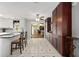 Bright kitchen featuring a breakfast bar, ceramic tile flooring, and extensive dark wood cabinetry at 923 Oleander St, The Villages, FL 32159