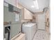 Bright laundry room with washer, dryer, cabinets, and tiled floors at 923 Oleander St, The Villages, FL 32159
