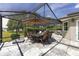 Outdoor dining set beneath an umbrella provides a relaxing setting on the large screened patio at 923 Oleander St, The Villages, FL 32159