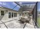 Covered patio features a dining set, outdoor grill and a smooth stone-style floor at 923 Oleander St, The Villages, FL 32159