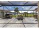 Inviting screened patio with outdoor kitchen and dining set offering picturesque views at 923 Oleander St, The Villages, FL 32159