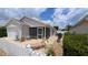 Exterior rear view featuring a screened lanai area, patio, and meticulously maintained landscaping at 971 Margaux Trl, The Villages, FL 32162