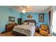 Cozy bedroom with a ceiling fan, wood floors, and comfortable seating at 971 Margaux Trl, The Villages, FL 32162