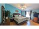 Charming bedroom featuring a ceiling fan, wood floors, and natural light at 971 Margaux Trl, The Villages, FL 32162