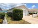 Side view of a home featuring a two-car garage with mature landscaping and well-kept lawn at 971 Margaux Trl, The Villages, FL 32162