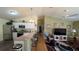 Open-concept kitchen with bar seating leading to a bright living room filled with ample seating and natural light at 971 Margaux Trl, The Villages, FL 32162