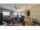 Bright living room with hardwood floors, large windows, comfortable seating, and access to the kitchen at 971 Margaux Trl, The Villages, FL 32162