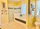 Bright bathroom featuring a glass enclosed shower, soaking tub, and classic tiled floor and shower surround at 974 Forest Hill Dr, Minneola, FL 34715