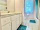 Bright bathroom with a tile floor, white vanity, and combination tub and shower at 974 Forest Hill Dr, Minneola, FL 34715
