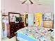 Charming bedroom featuring a vaulted ceiling, dresser with mirror, and a view into the en-suite bathroom at 974 Forest Hill Dr, Minneola, FL 34715