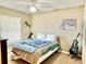Comfortable bedroom featuring a ceiling fan, double bed, and plenty of natural light from the window at 974 Forest Hill Dr, Minneola, FL 34715