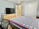 Bedroom featuring a television, drawers, closet, and inviting double bed with a colorful quilt at 974 Forest Hill Dr, Minneola, FL 34715