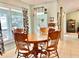Cozy dining room with a wooden table and chairs, illuminated by natural light from large windows at 974 Forest Hill Dr, Minneola, FL 34715