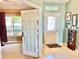 View of the entryway featuring tile floors and decorations, with an open doorway leading to a carpeted room and bright window at 974 Forest Hill Dr, Minneola, FL 34715