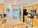 Well-lit kitchen features granite countertops, stainless steel appliances, and wood cabinets at 974 Forest Hill Dr, Minneola, FL 34715