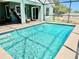 Screened-in pool features crystal-clear water and a spacious deck, creating a perfect outdoor oasis for relaxation and entertainment at 974 Forest Hill Dr, Minneola, FL 34715