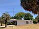 Low-angle shot of a well-maintained single story home and lush green lawn at 1030 Vermont Ave, Lady Lake, FL 32159