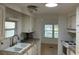 Bright kitchen with white cabinets, tile countertops, and a view into the dining area at 1030 Vermont Ave, Lady Lake, FL 32159