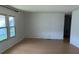 Spacious living room featuring natural light from the windows and light wood laminate flooring at 1030 Vermont Ave, Lady Lake, FL 32159