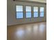 Bright living room featuring large windows and light wood laminate flooring at 1030 Vermont Ave, Lady Lake, FL 32159