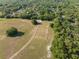 An aerial view displays a fenced space and round pen, with lush trees surrounding the property at 111 Kentucky Blue Cir, Apopka, FL 32712