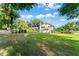 Expansive backyard with lush lawn, mature trees, and view of screened in patio and home at 111 Kentucky Blue Cir, Apopka, FL 32712