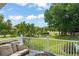 Scenic backyard view from patio with seating, showcasing lush landscaping, mature trees, and white picket fence at 111 Kentucky Blue Cir, Apopka, FL 32712