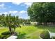 Beautifully landscaped backyard with lush green grass, mature trees, and white fencing on a sunny day at 111 Kentucky Blue Cir, Apopka, FL 32712
