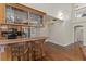 Nice home bar area featuring custom wooden cabinets and hardwood flooring at 111 Kentucky Blue Cir, Apopka, FL 32712
