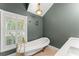 Bright bathroom showcasing a clawfoot tub, pendant lighting, and a window with plantation shutters at 111 Kentucky Blue Cir, Apopka, FL 32712