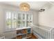 Bright Bedroom featuring shuttered windows, a crib, and a decorative light fixture at 111 Kentucky Blue Cir, Apopka, FL 32712
