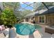 Inviting screened-in pool area with lush greenery, a hot tub, and ample space for relaxation at 111 Kentucky Blue Cir, Apopka, FL 32712
