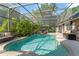 Inviting screened-in pool area with lush greenery, a hot tub, and ample space for relaxation at 111 Kentucky Blue Cir, Apopka, FL 32712