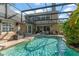 A beautiful screened in pool with crystal clear water sits adjacent to a stone-clad home at 111 Kentucky Blue Cir, Apopka, FL 32712