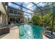 Screened-in pool area with tropical landscaping and a waterfall feature, creating a private oasis at 111 Kentucky Blue Cir, Apopka, FL 32712