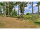 Large backyard featuring mature trees providing shade and a view of the covered dock at 1110 Fairfax St, Leesburg, FL 34748