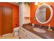 Bright bathroom featuring an orange wall, granite countertops, and a walk-in shower at 1110 Fairfax St, Leesburg, FL 34748
