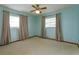 Bedroom with ceiling fan, neutral carpeting, and curtains at 1110 Fairfax St, Leesburg, FL 34748
