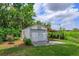 Exterior of detached garage with a carport and surrounded by mature landscaping at 1110 Fairfax St, Leesburg, FL 34748