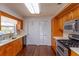 Galley-style kitchen featuring light-toned counters and wooden cabinets plus stainless steel appliances at 1110 Fairfax St, Leesburg, FL 34748