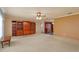 Spacious living room with plush carpet, a ceiling fan, and beautiful wooden built-in shelving at 1110 Fairfax St, Leesburg, FL 34748