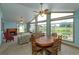 Bright living room with vaulted ceilings, fireplace, ceiling fans, and large windows overlooking the outdoor scenery at 1110 Fairfax St, Leesburg, FL 34748