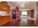 A view from the kitchen into the large living area, complete with hardwood floors and classic chandelier at 1110 Fairfax St, Leesburg, FL 34748